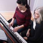 Female adult learning to play the piano